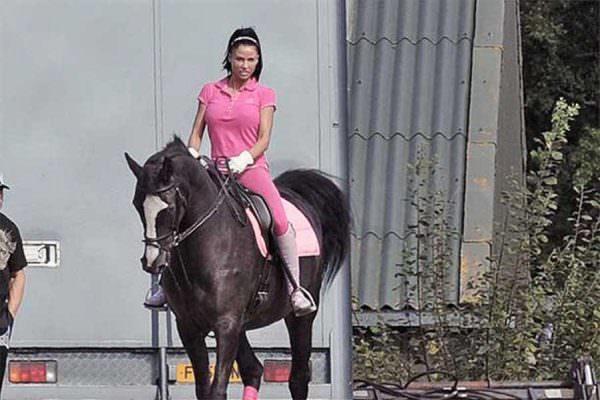 Katie Price rides big black horse in pink riding outfit