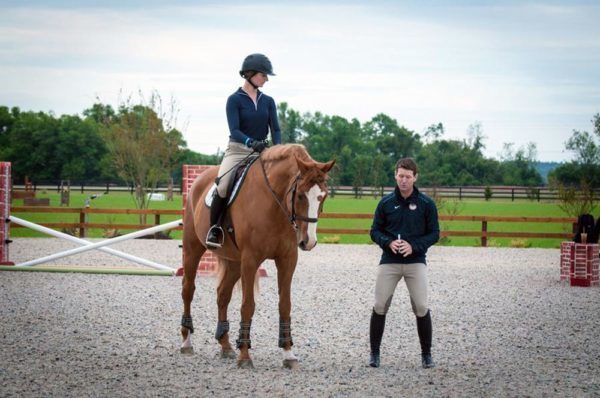 A rider listens as her coach discusses riding technique.